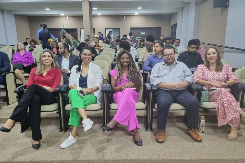 Auditório com pessoas sentadas nas cadeiras